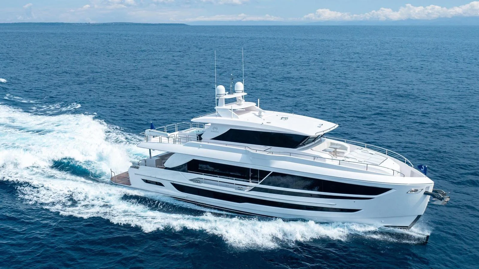 A sleek and modern yacht cruising through open waters on a sunny day. aboard HAPPY HEART Yacht for Sale