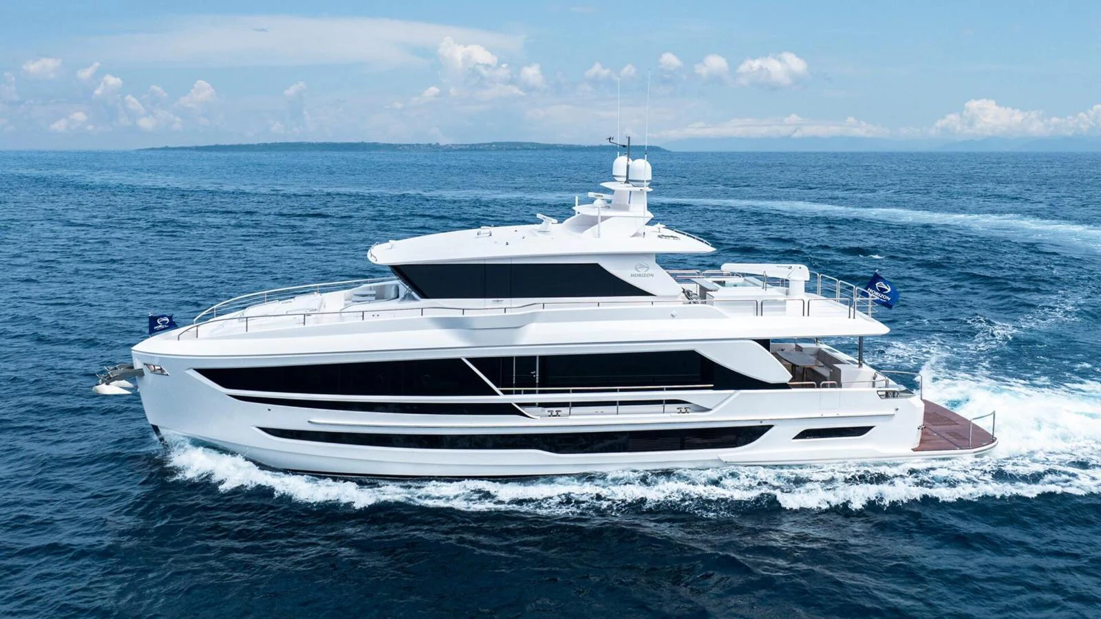 A sleek and modern yacht cruising on open water under a clear sky. aboard HAPPY HEART Yacht for Sale