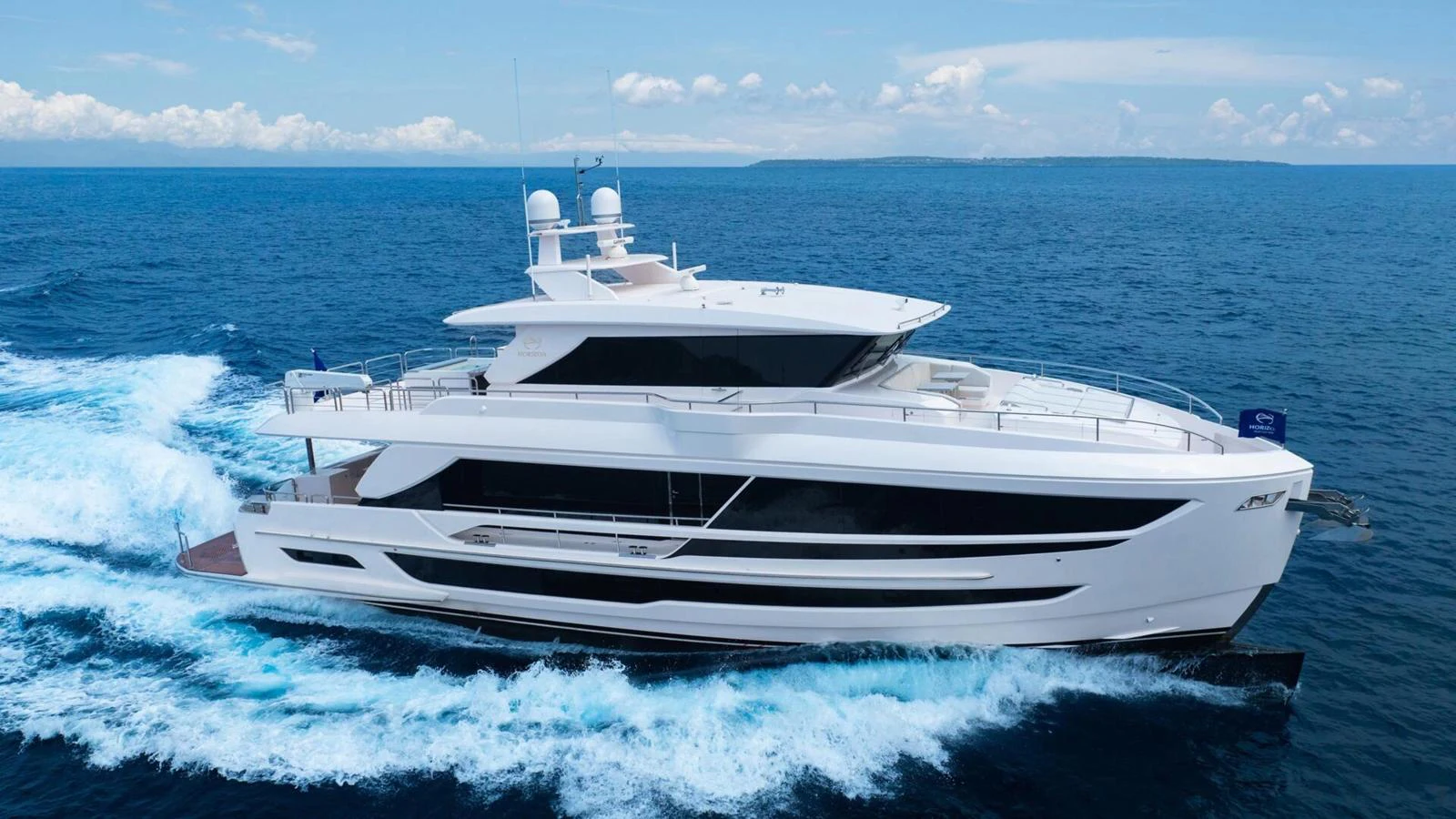 A sleek and modern yacht cruises through the open sea, showcasing its elegant design and spacious decks. aboard HAPPY HEART Yacht for Sale