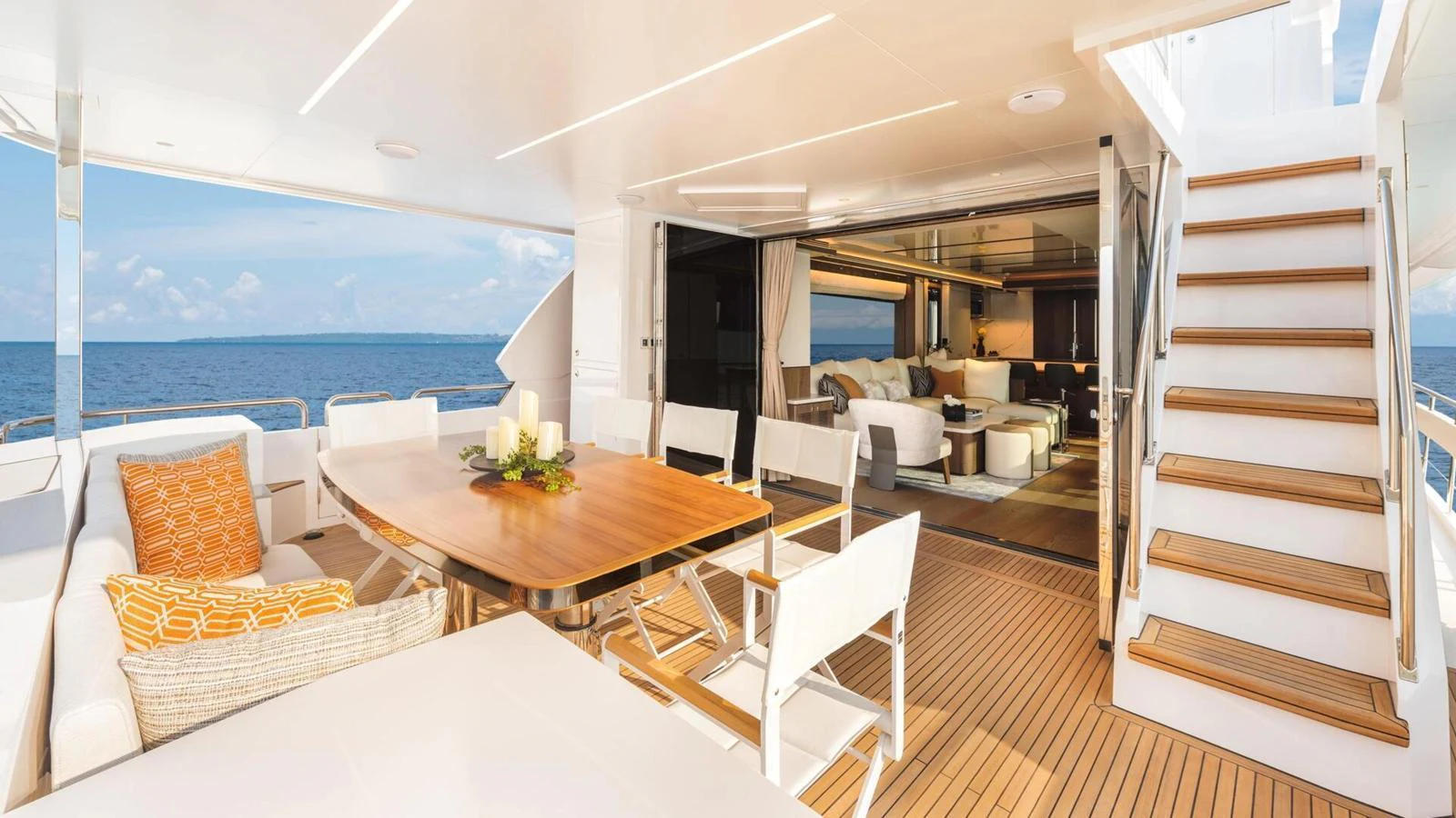 The aft deck features a spacious seating area with a dining table and seamless indoor-outdoor flow. aboard HAPPY HEART Yacht for Sale