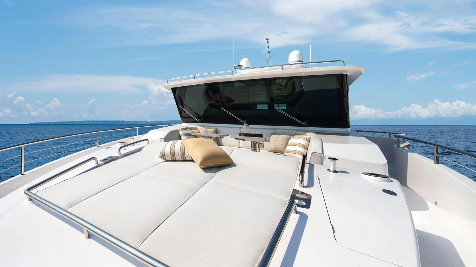 The foredeck features a spacious sunbathing area with plush cushions and a stunning ocean view. aboard HAPPY HEART Yacht for Sale