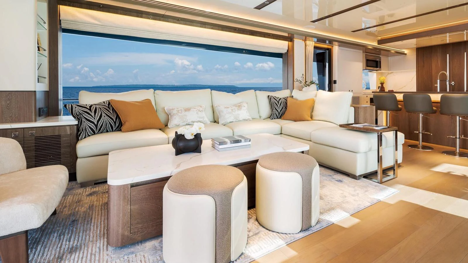 The salon features luxurious seating with a stunning ocean view through large windows. aboard HAPPY HEART Yacht for Sale