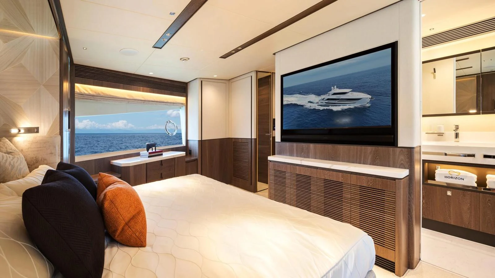 The master stateroom features a luxurious bed, a large window with an ocean view, and a flat-screen TV. aboard HAPPY HEART Yacht for Sale