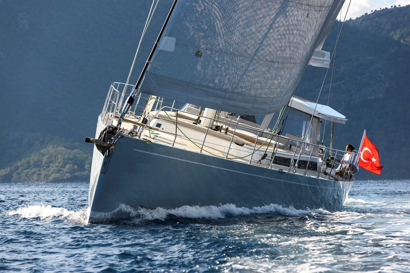 A sleek sailing yacht glides through the water with its sails fully extended. aboard MISHI Yacht for Sale