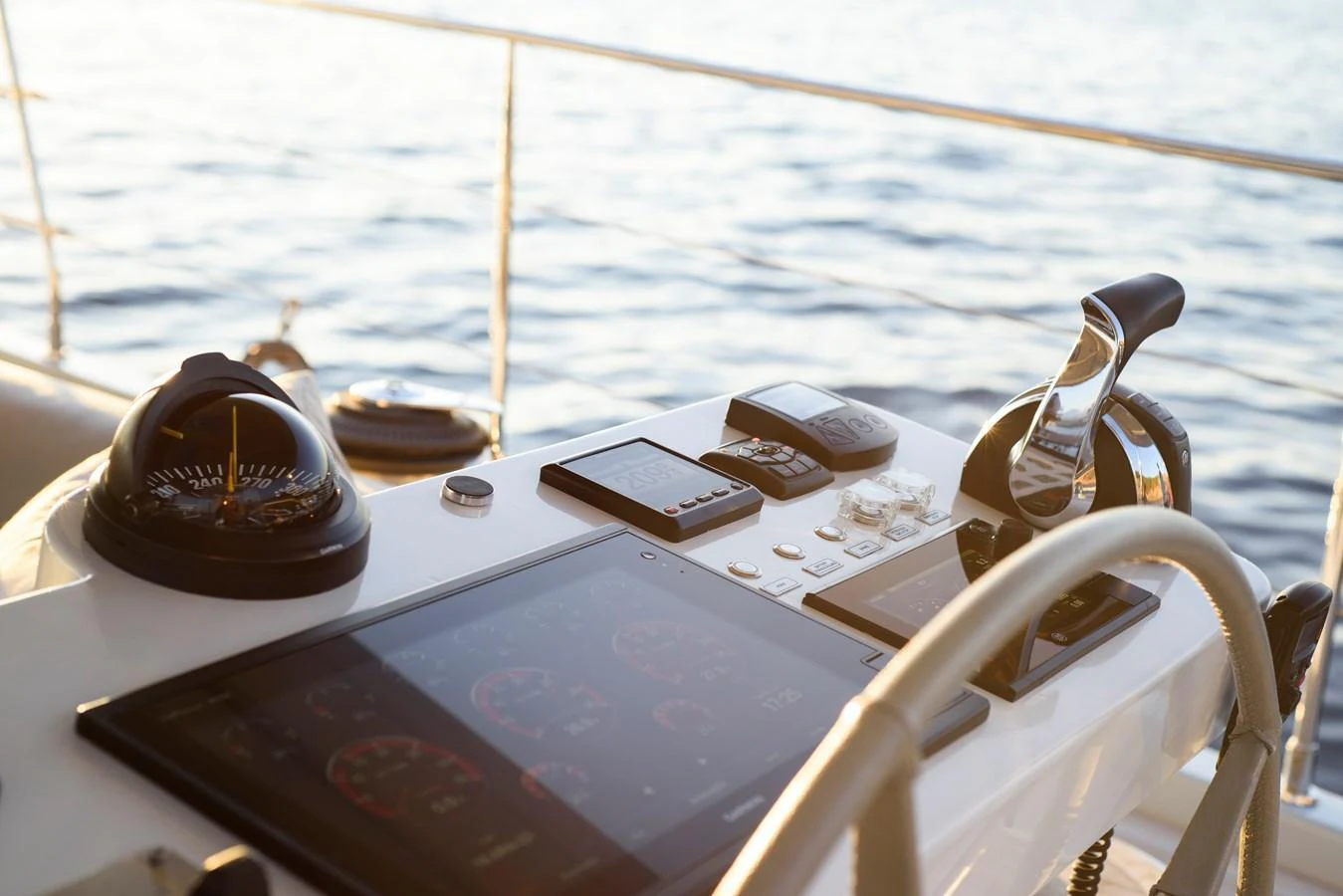The helm station features advanced navigation instruments and controls, set against a serene ocean backdrop. aboard MISHI Yacht for Sale