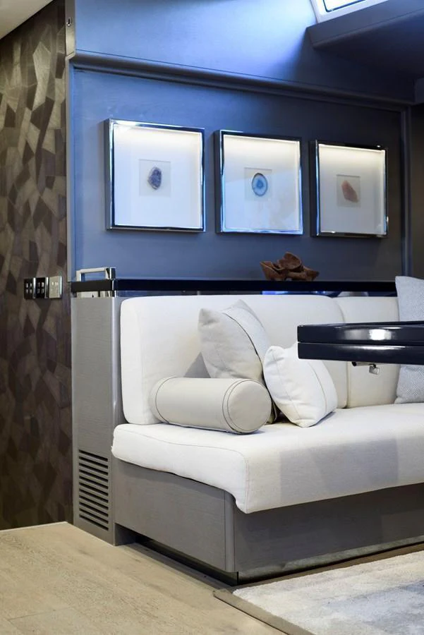 The yacht's interior features a cozy seating area with elegant decor and framed artwork. aboard MISHI Yacht for Sale