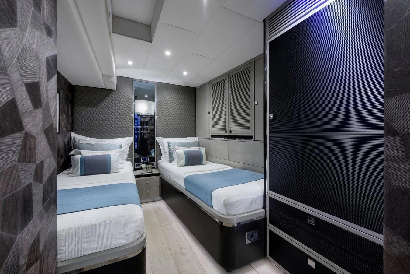 The twin stateroom features modern decor with two single beds and elegant lighting. aboard MISHI Yacht for Sale