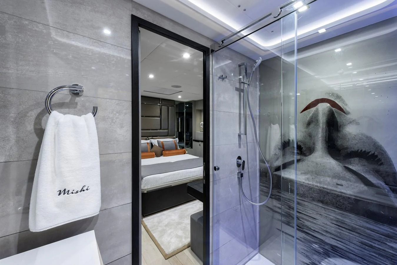 The image showcases a luxurious yacht bathroom with a view into a modern stateroom. aboard MISHI Yacht for Sale