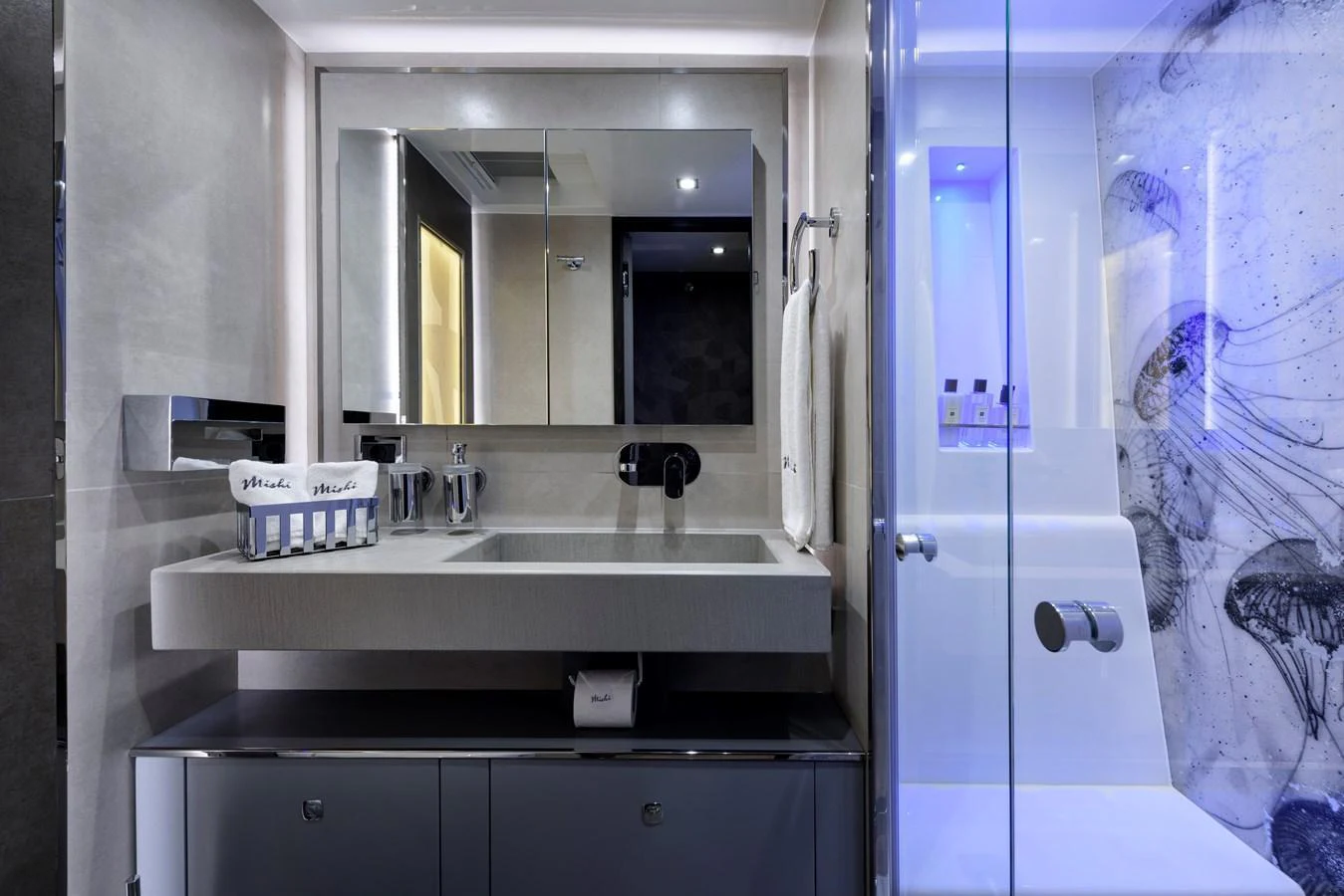 A sleek and modern yacht bathroom with contemporary fixtures and a glass-enclosed shower. aboard MISHI Yacht for Sale