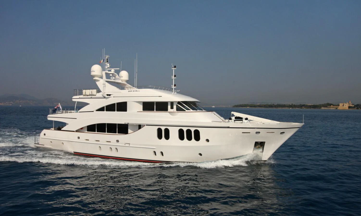 A sleek and elegant yacht cruising on calm waters under a clear sky. aboard SEA SHELL Yacht for Sale