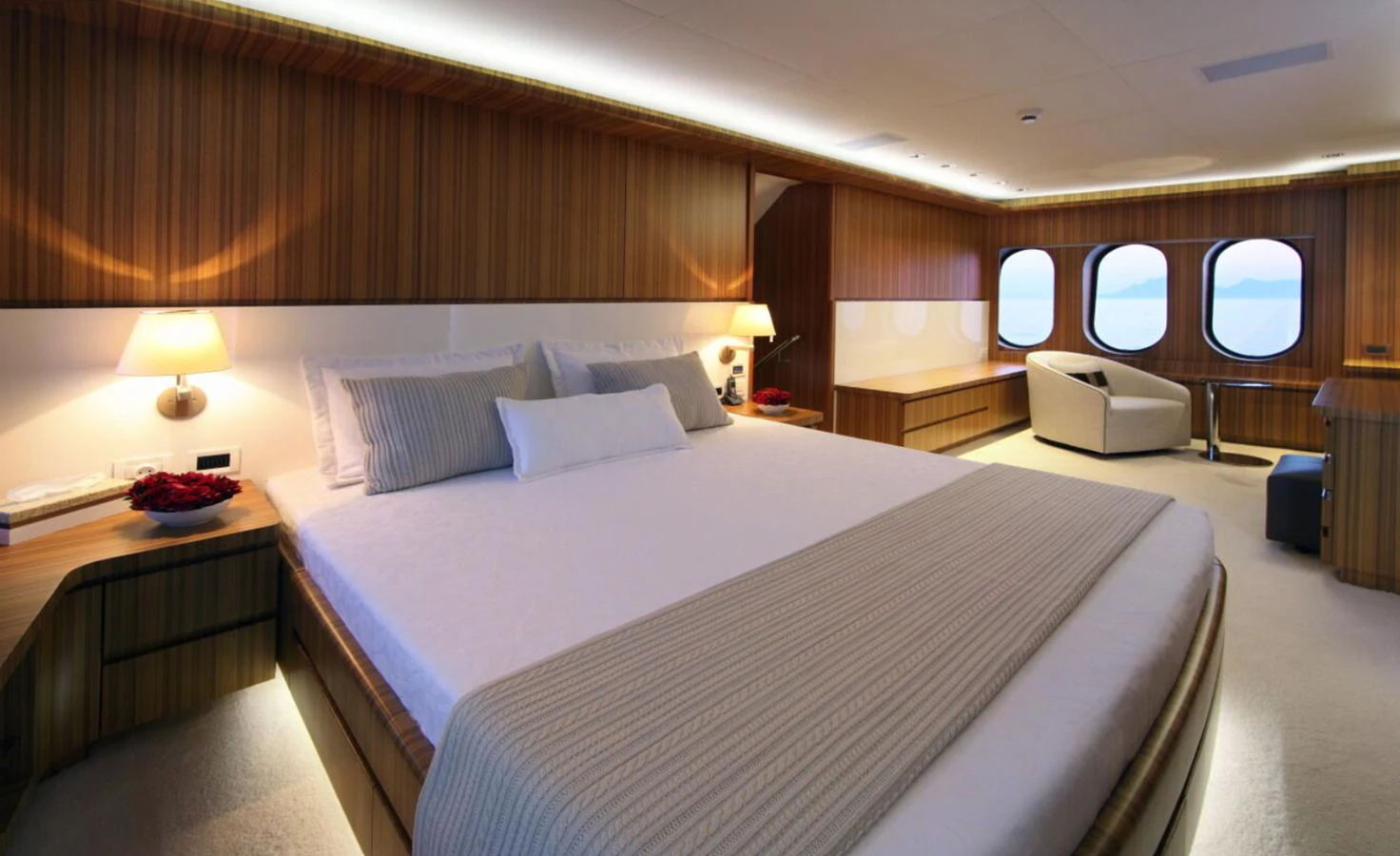 The master stateroom features a large bed, warm wood paneling, and ample natural light from the windows. aboard SEA SHELL Yacht for Sale