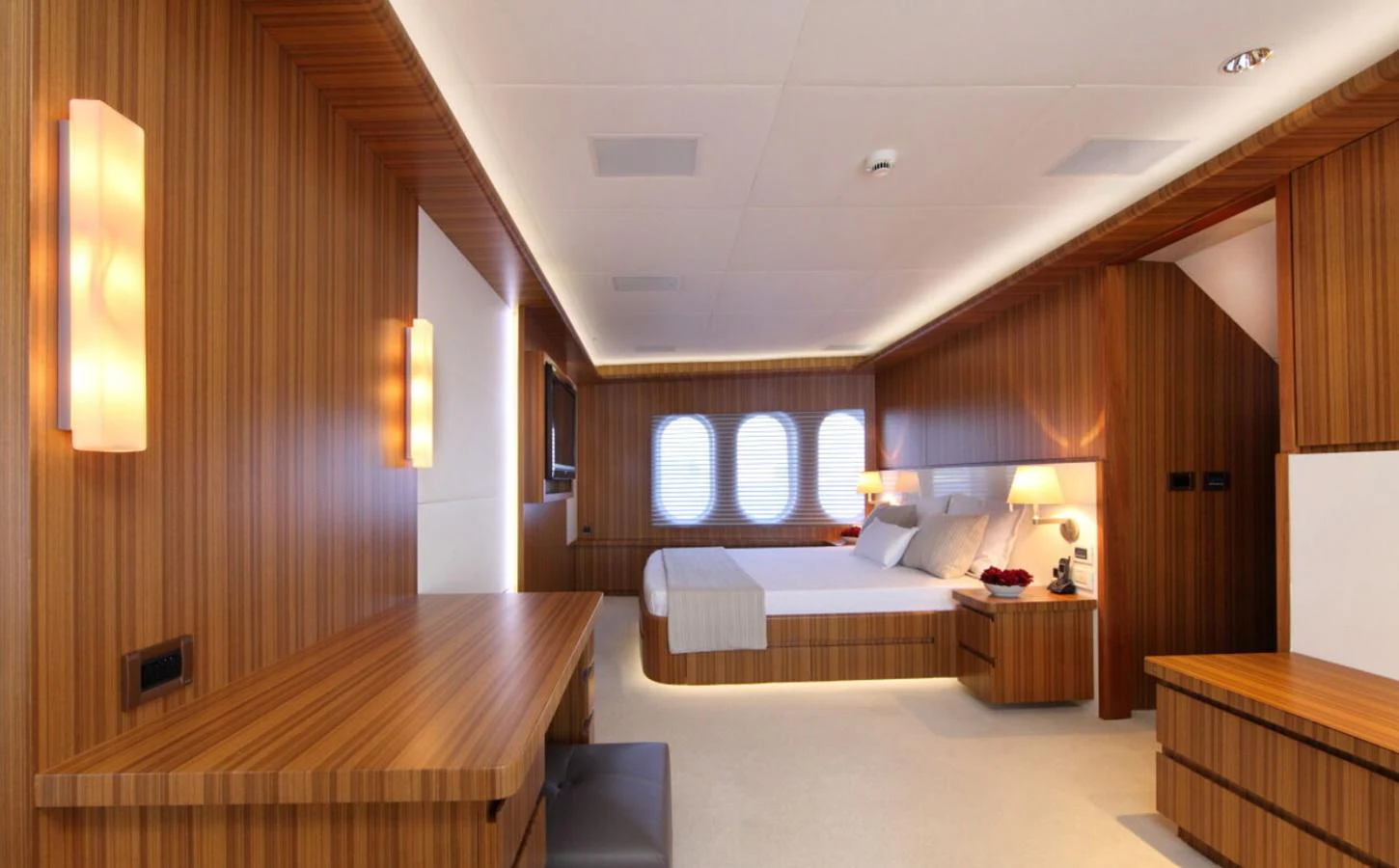 The master stateroom features elegant wood paneling and modern lighting, creating a warm and inviting atmosphere. aboard SEA SHELL Yacht for Sale