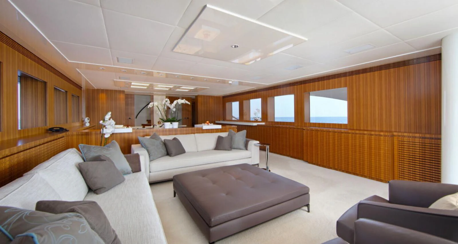 The salon features elegant seating with panoramic views through large windows. aboard SEA SHELL Yacht for Sale