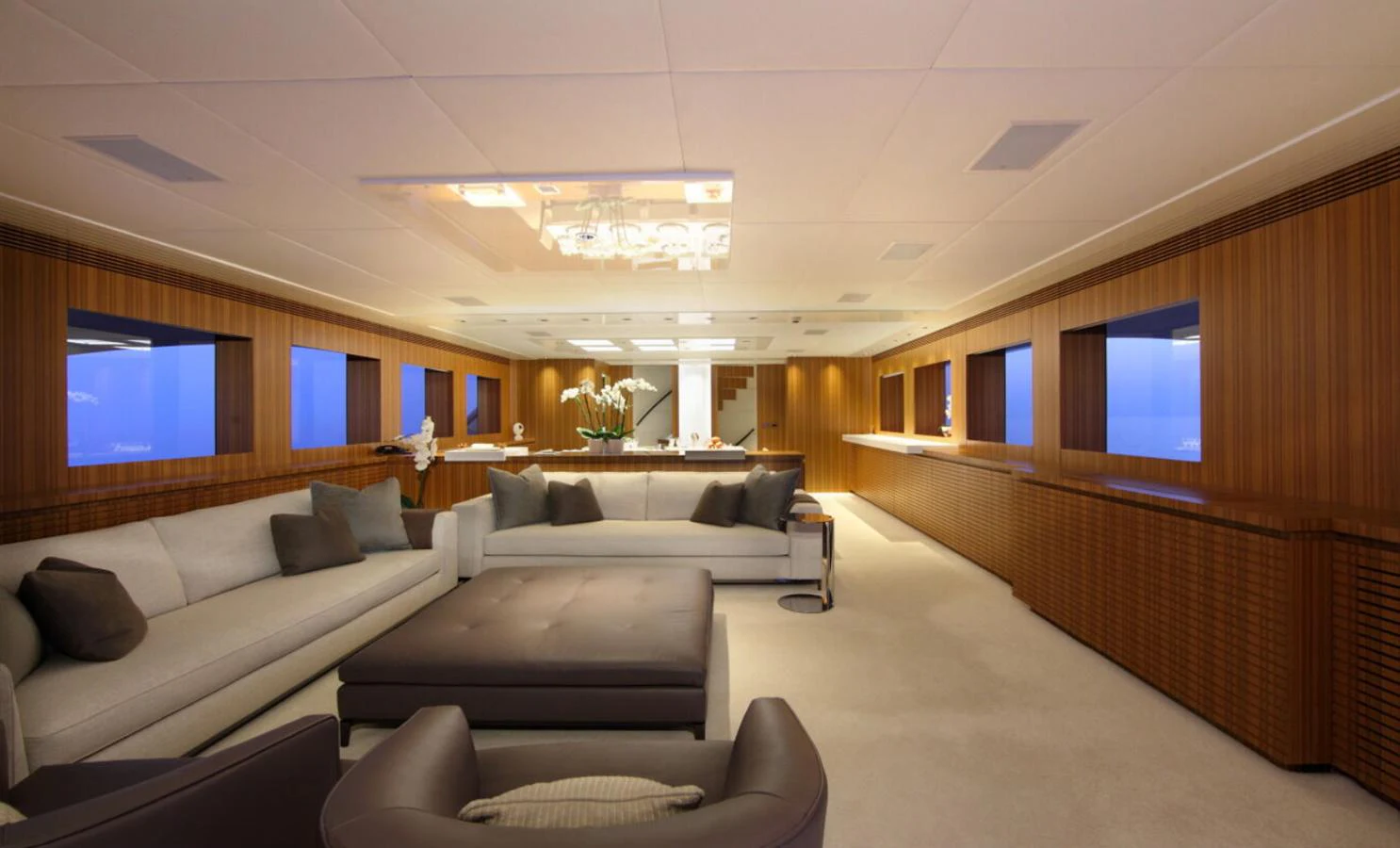 The salon features elegant wood paneling, plush seating, and large windows offering a serene ambiance. aboard SEA SHELL Yacht for Sale