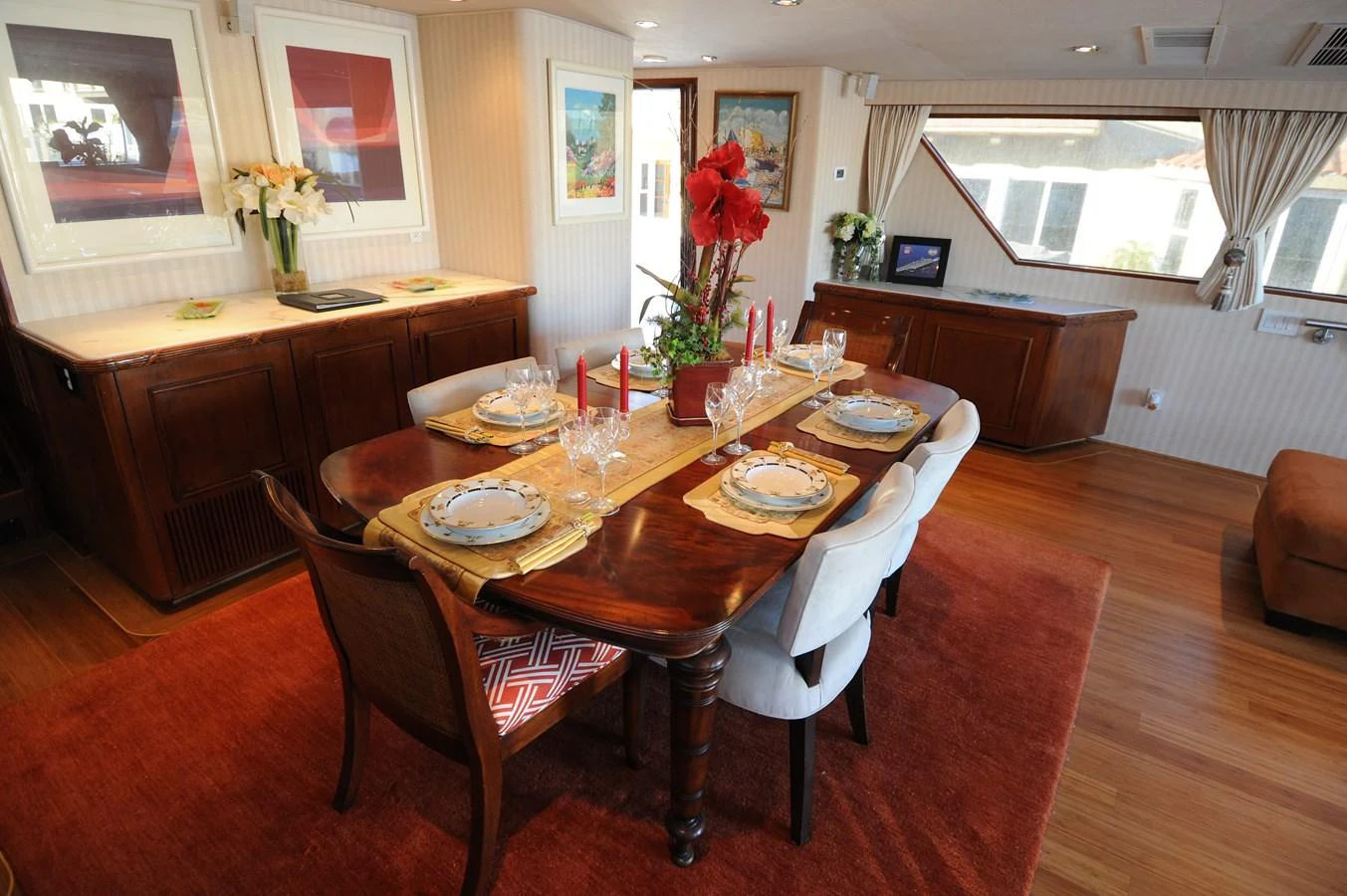 The yacht's dining area features an elegant table set for a meal, surrounded by comfortable chairs and warm decor. aboard BURNING DAYLIGHT Yacht for Sale