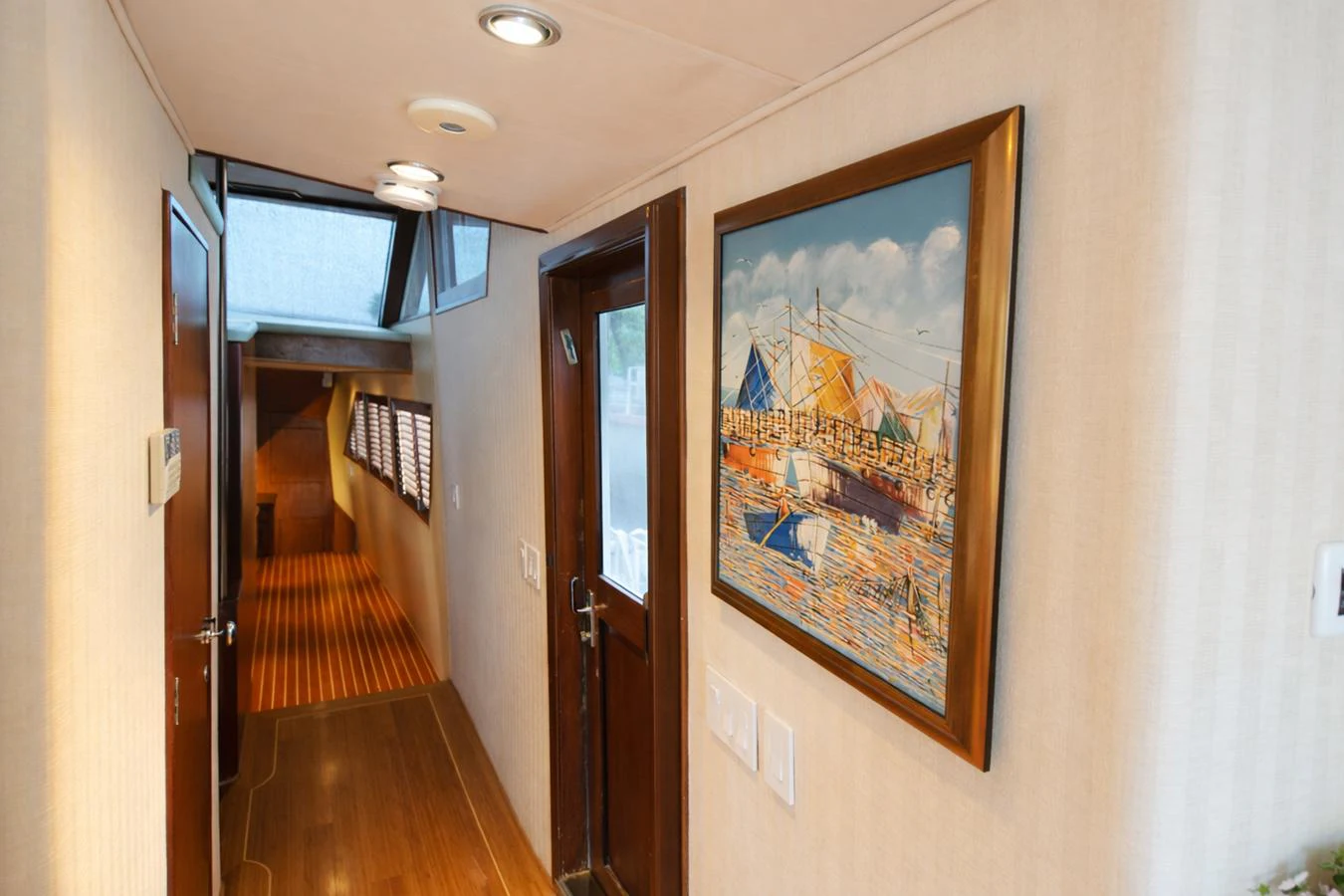 A well-lit hallway featuring a nautical painting and wooden accents. aboard BURNING DAYLIGHT Yacht for Sale