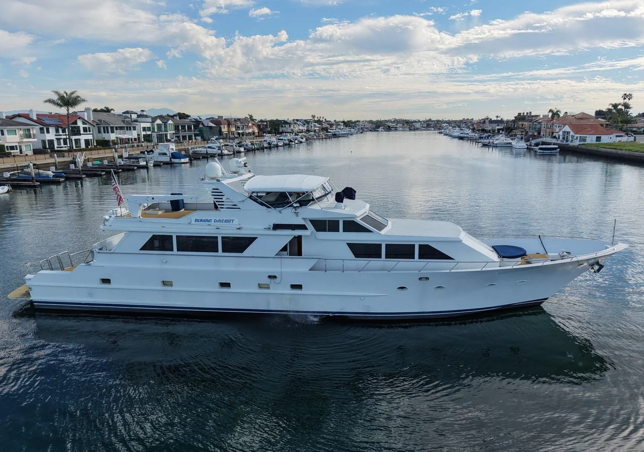 A sleek and elegant yacht cruises through a serene waterway, showcasing its luxurious design and spacious decks. aboard BURNING DAYLIGHT Yacht for Sale
