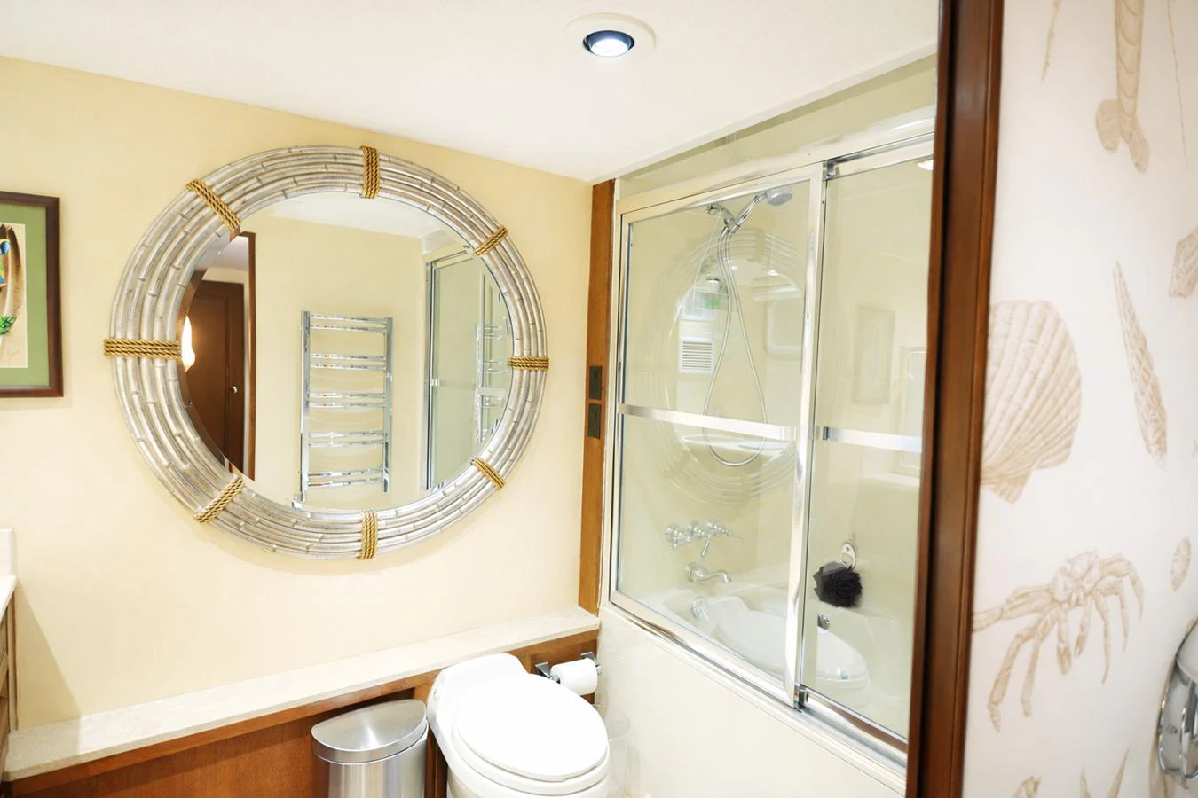 The yacht's bathroom features a modern design with elegant fixtures and a large circular mirror. aboard BURNING DAYLIGHT Yacht for Sale