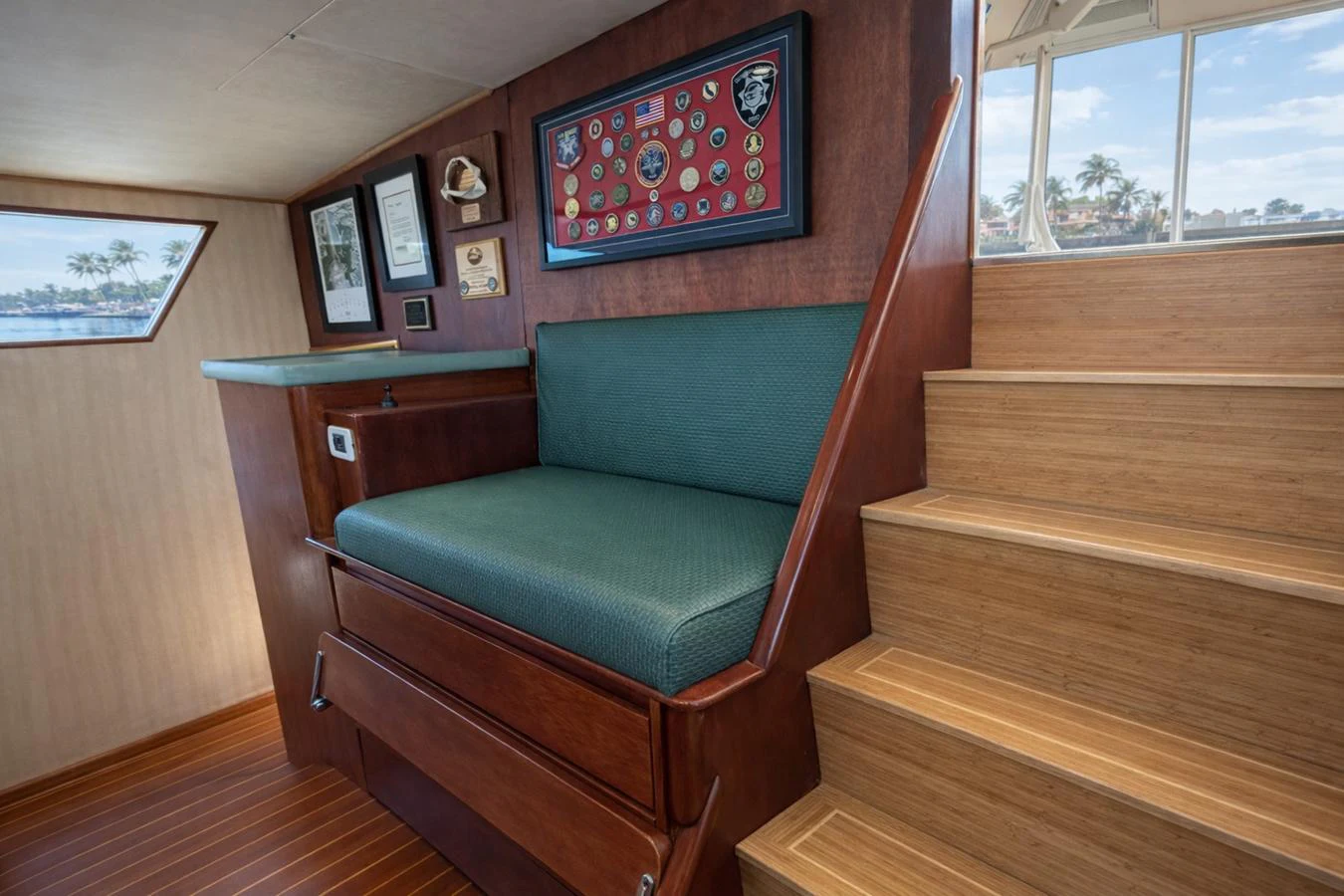 A cozy interior seating area with wooden stairs and a display of memorabilia. aboard BURNING DAYLIGHT Yacht for Sale
