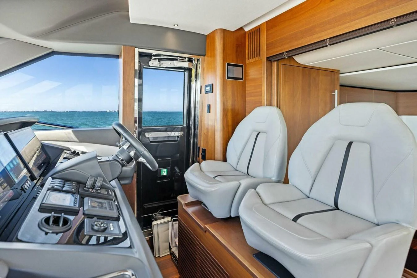 The helm area features modern controls and comfortable seating with a view of the sea. aboard 3BBOYS Yacht for Sale