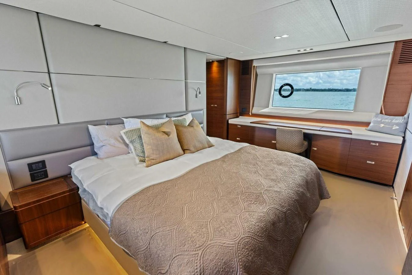 A luxurious stateroom featuring a large bed, modern furnishings, and a scenic window view. aboard 3BBOYS Yacht for Sale