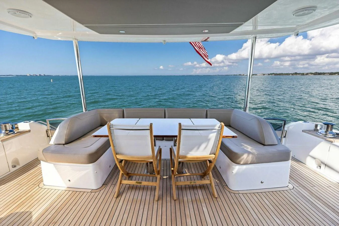 The aft deck features a spacious seating area with a dining table, perfect for enjoying meals with a view of the sea. aboard 3BBOYS Yacht for Sale