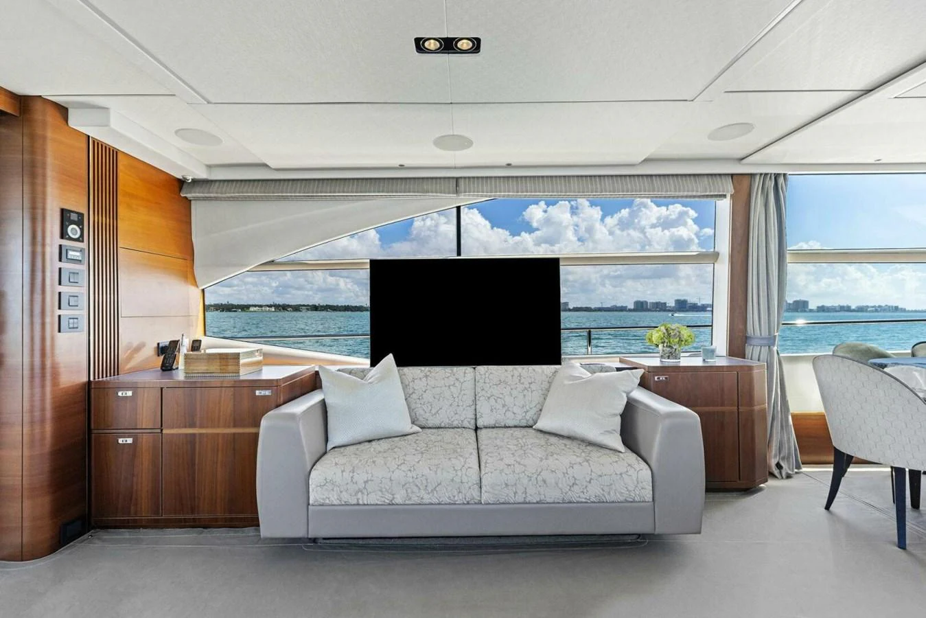 The salon features a comfortable sofa with a stunning view of the sea through large windows. aboard 3BBOYS Yacht for Sale