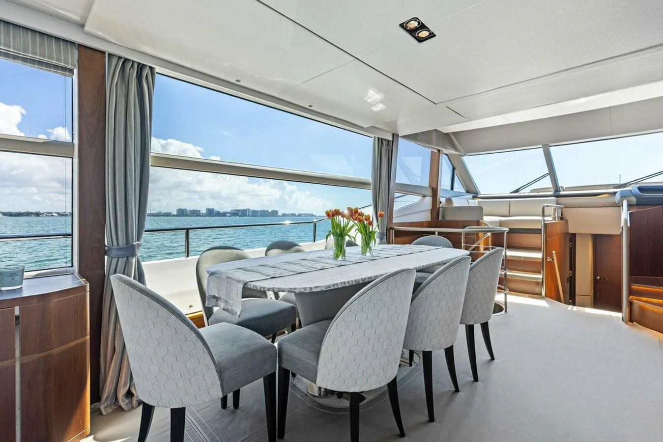 The yacht's dining area features a modern table set with a panoramic view of the sea. aboard 3BBOYS Yacht for Sale