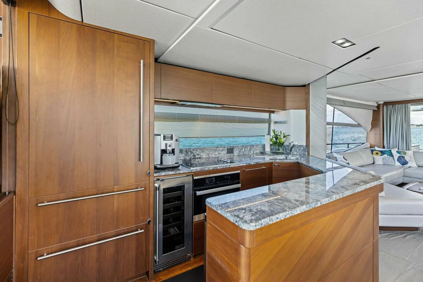 The yacht's galley features modern appliances and elegant wood cabinetry with a view of the sea. aboard 3BBOYS Yacht for Sale