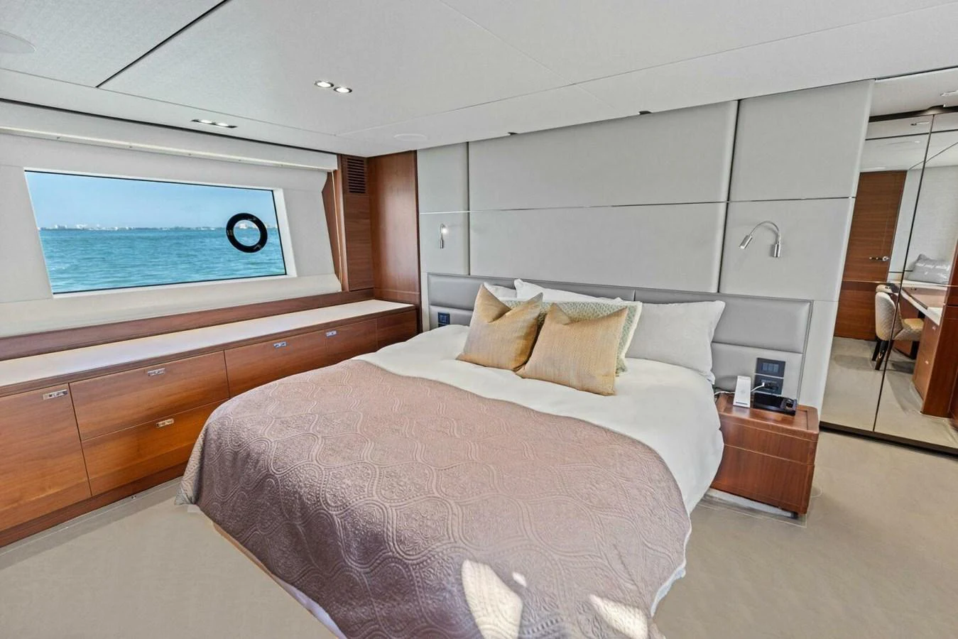 A luxurious stateroom with a large bed and a scenic ocean view through the window. aboard 3BBOYS Yacht for Sale