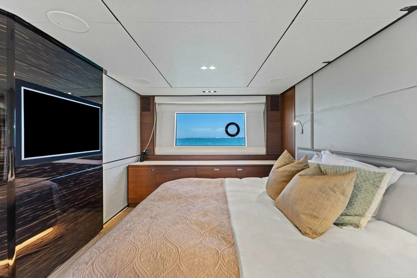 A luxurious stateroom with a large bed, modern decor, and a window offering a serene ocean view. aboard 3BBOYS Yacht for Sale