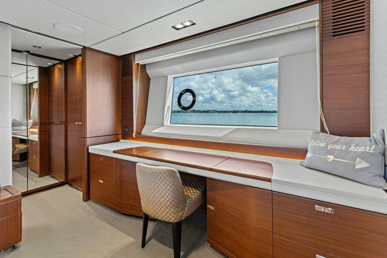 A luxurious yacht interior featuring a desk area with a scenic window view. aboard 3BBOYS Yacht for Sale