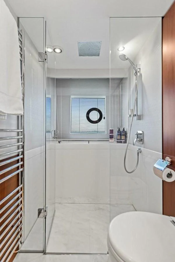 A sleek and modern yacht bathroom with glass shower enclosure and contemporary fixtures. aboard 3BBOYS Yacht for Sale