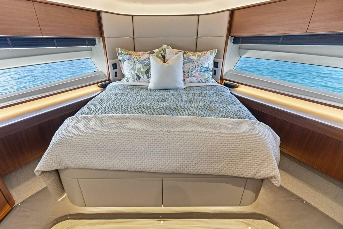 The stateroom features a luxurious bed with elegant bedding and large windows offering a serene view of the water. aboard 3BBOYS Yacht for Sale