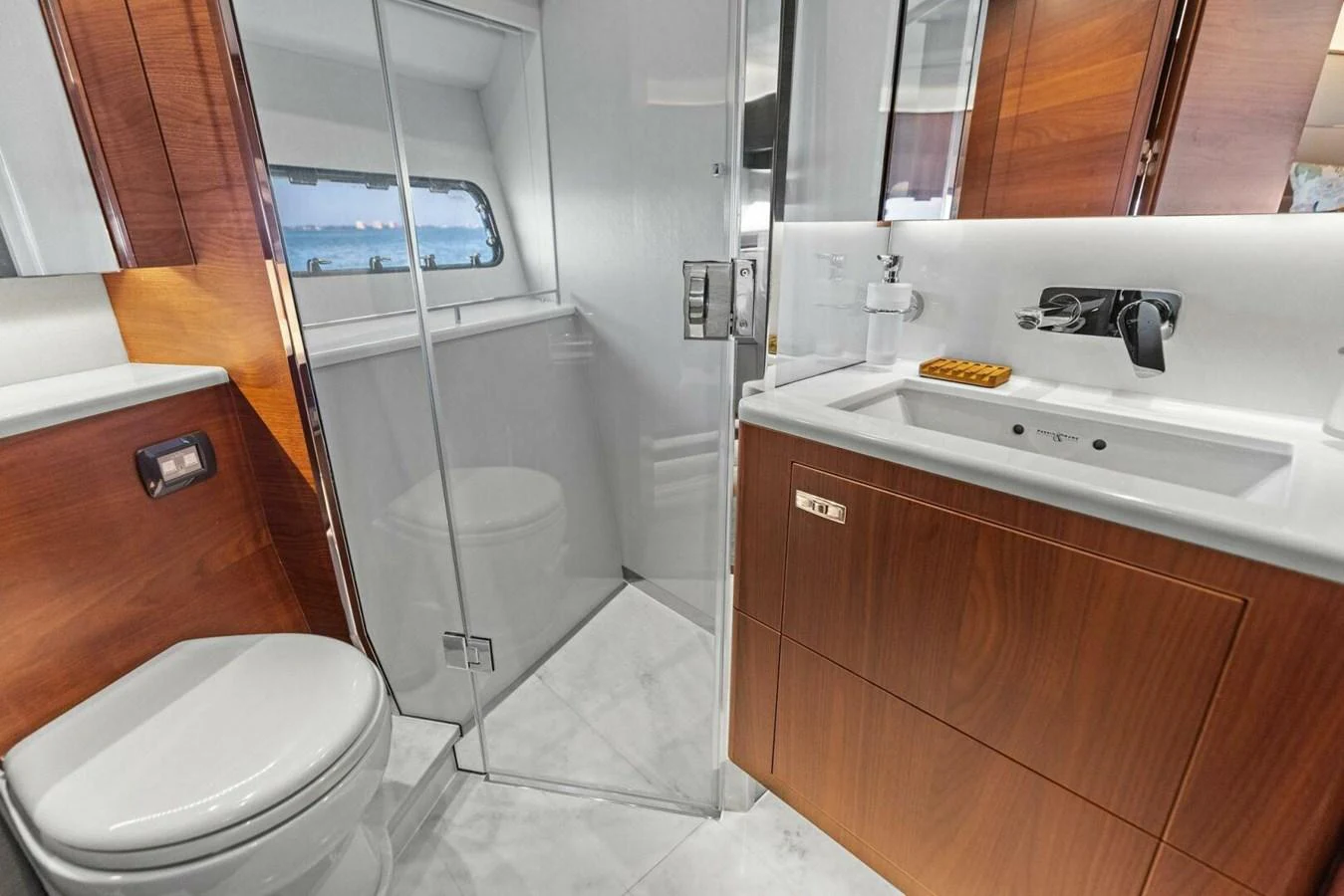 The yacht's bathroom features modern fixtures and a sleek design with wooden cabinetry and a glass-enclosed shower. aboard 3BBOYS Yacht for Sale
