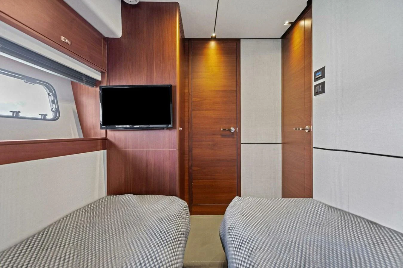 The guest cabin features twin beds, a wall-mounted TV, and elegant wood paneling. aboard 3BBOYS Yacht for Sale