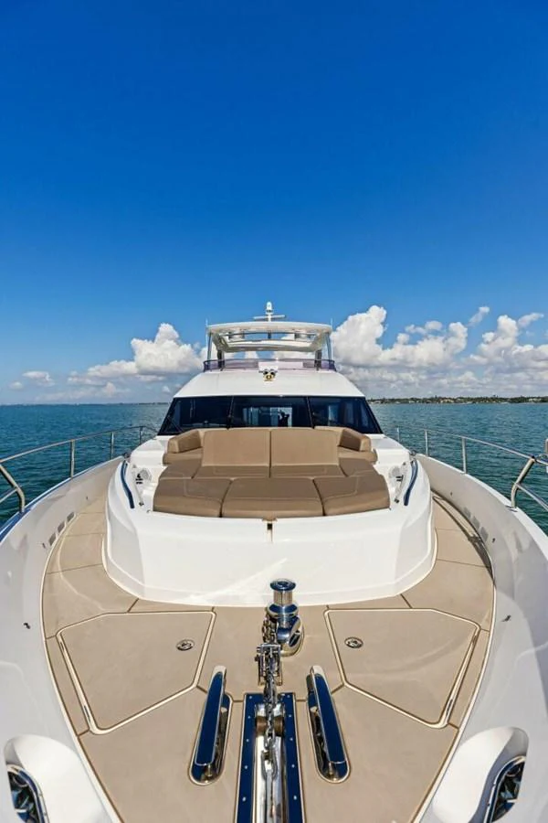 The yacht's foredeck features spacious seating and a sleek design under a clear blue sky. aboard 3BBOYS Yacht for Sale