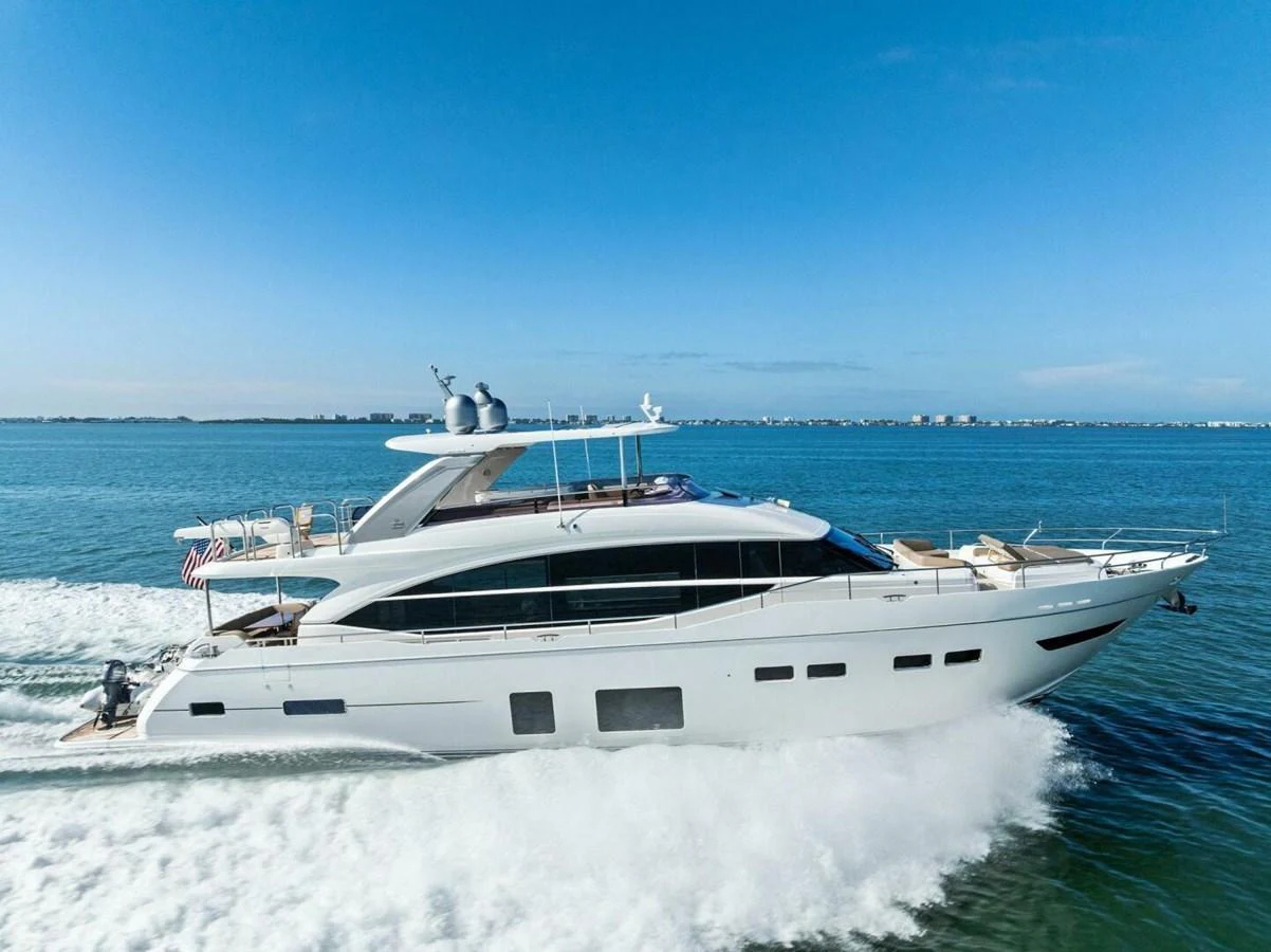 A sleek and modern yacht cruising swiftly on the open water under a clear blue sky. aboard 3BBOYS Yacht for Sale