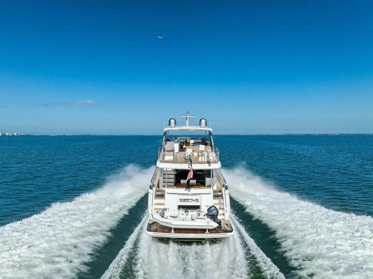 A luxurious yacht cruises through the open water, leaving a trail of white waves behind. aboard 3BBOYS Yacht for Sale