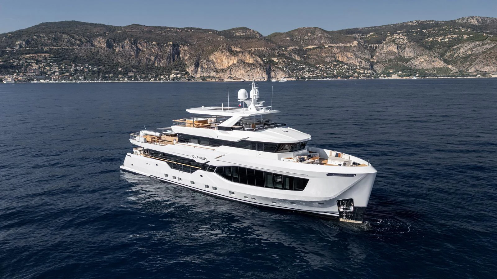 A luxurious yacht cruises through calm waters with a scenic coastal backdrop. aboard NUMARINE 37XP-21 Yacht for Sale