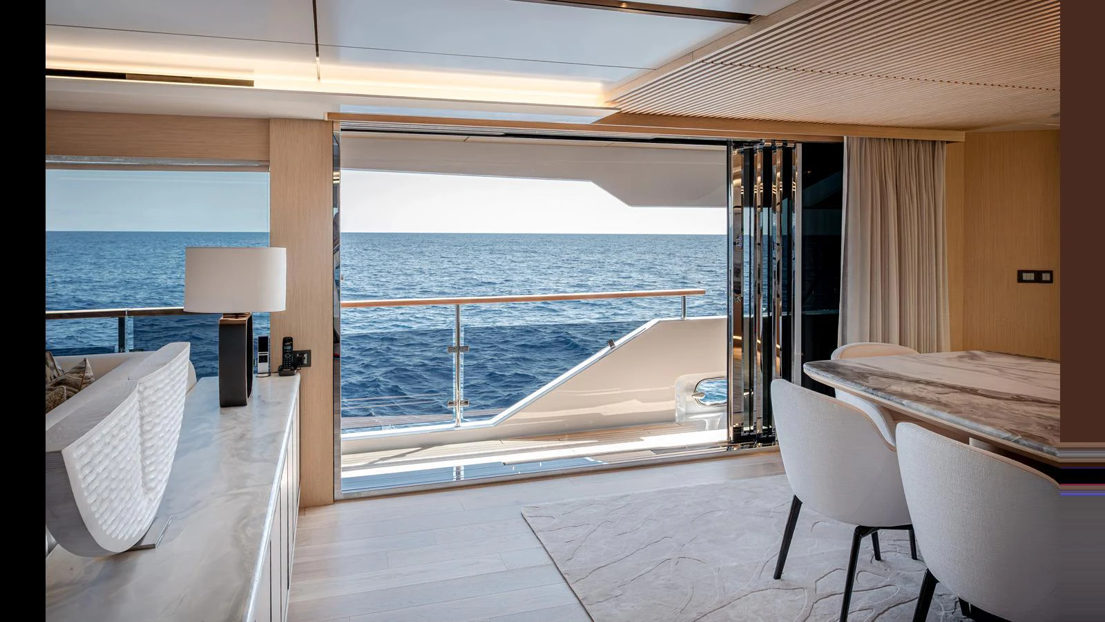 The salon offers a luxurious and open view of the sea through large sliding glass doors. aboard NUMARINE 37XP-21 Yacht for Sale