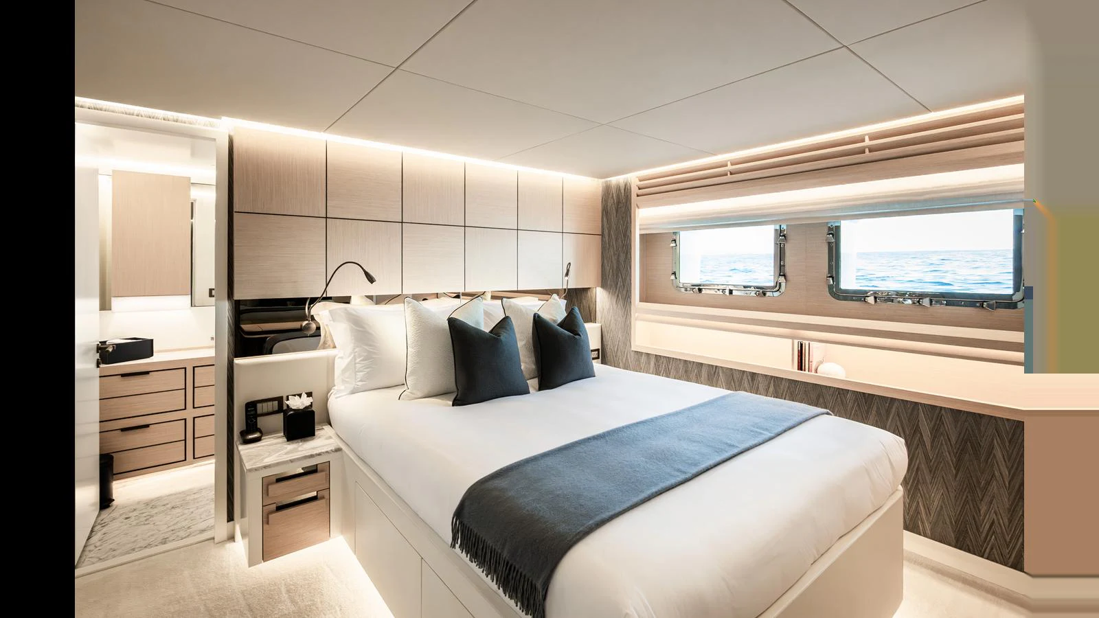 The master stateroom features a luxurious bed with elegant lighting and ocean views through large windows. aboard NUMARINE 37XP-21 Yacht for Sale