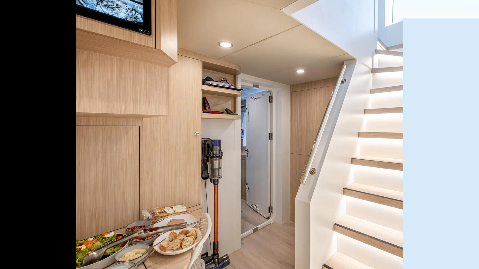 A well-lit interior space featuring a staircase, storage area, and a small dining setup. aboard NUMARINE 37XP-21 Yacht for Sale