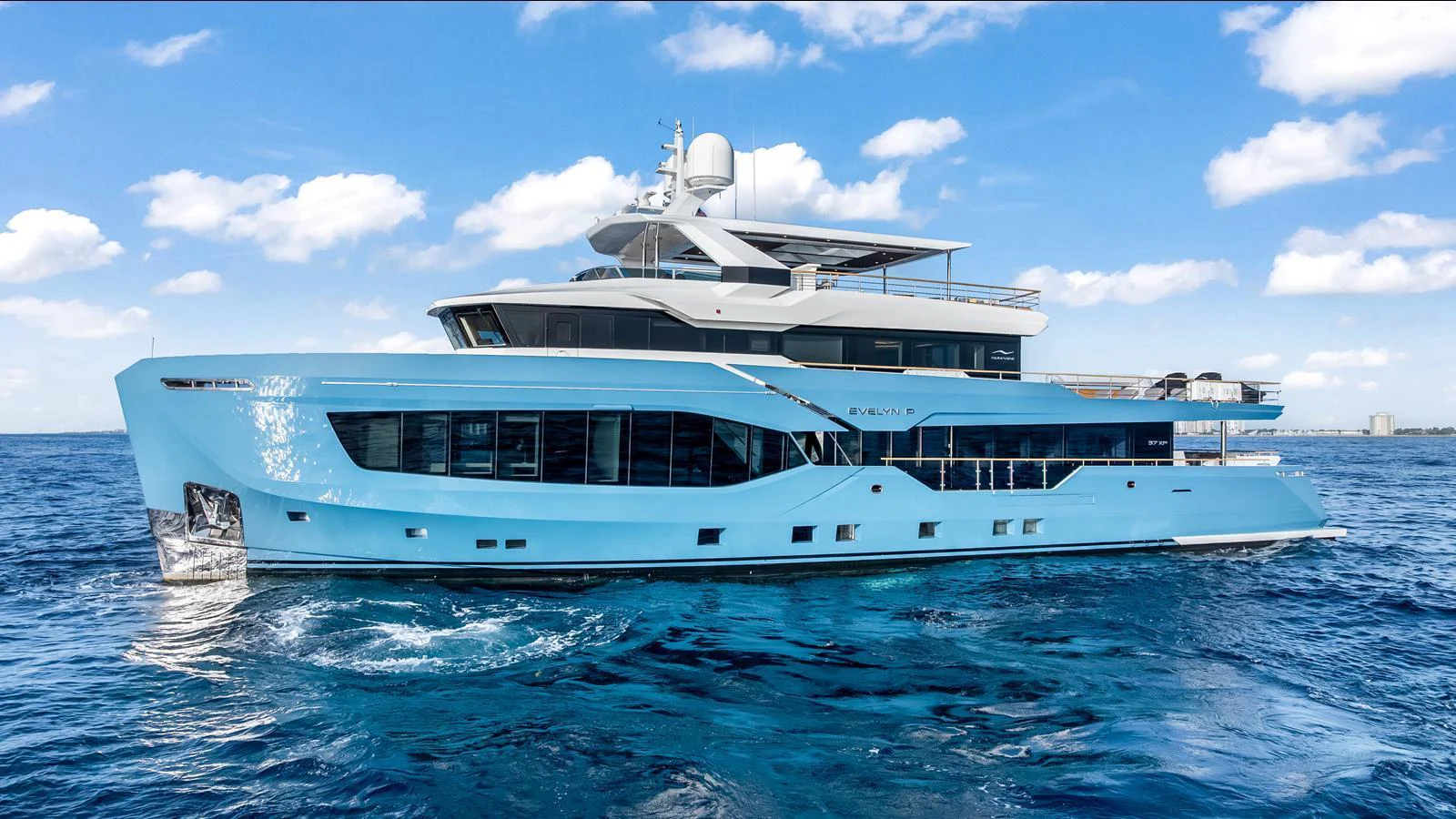 A sleek and modern yacht glides through the water under a clear blue sky. aboard NUMARINE 37XP-21 Yacht for Sale