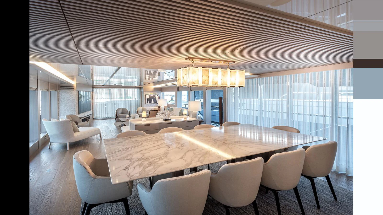 The yacht's dining area features a luxurious marble table and plush seating, bathed in natural light from large windows. aboard NUMARINE 37XP-21 Yacht for Sale