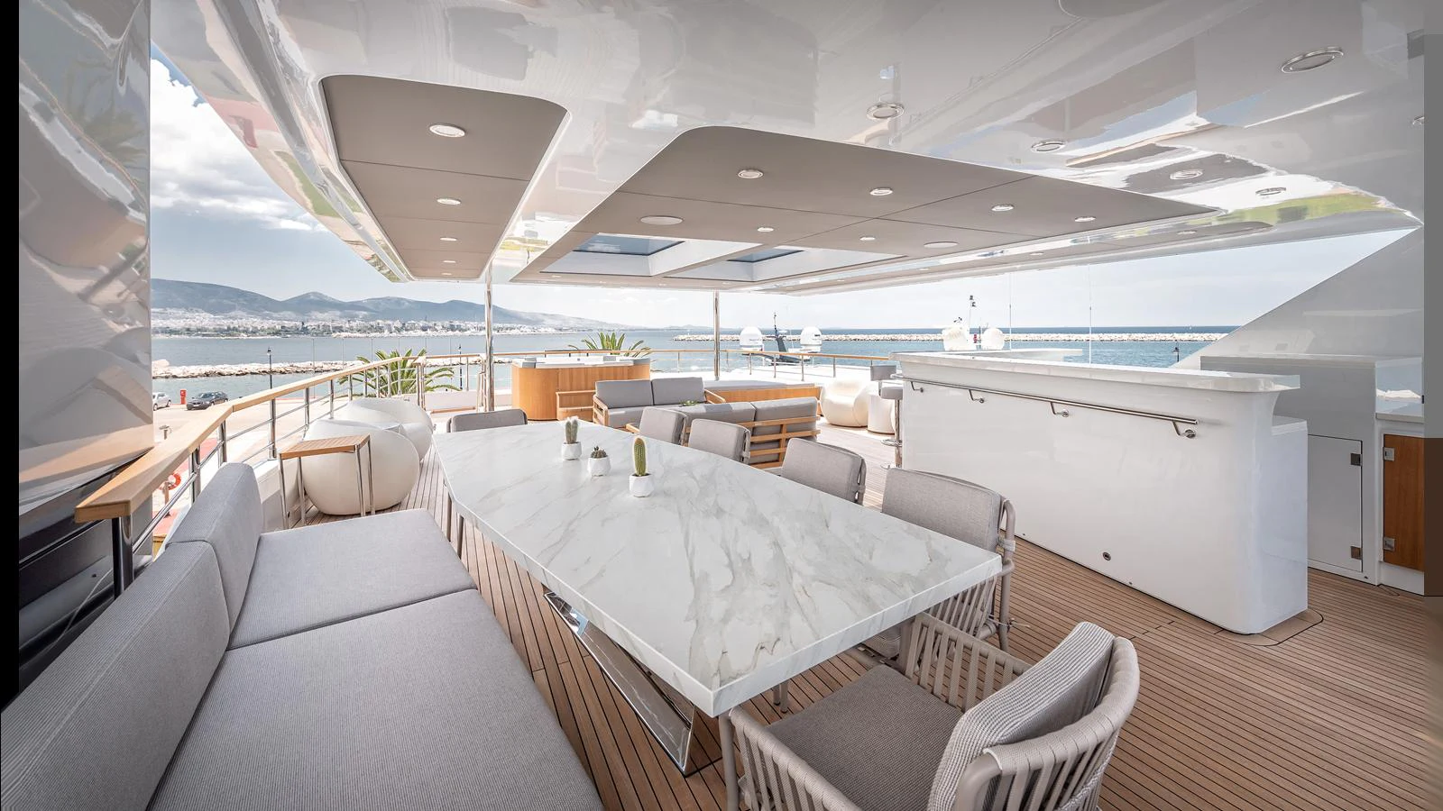 The aft deck features a spacious dining area with a sleek marble table and comfortable seating, perfect for alfresco dining. aboard NUMARINE 37XP-21 Yacht for Sale