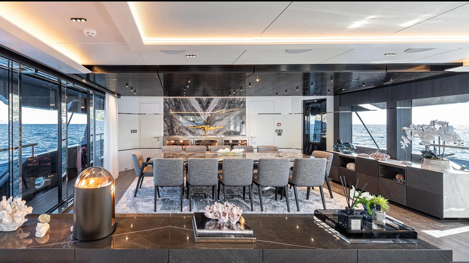The yacht's salon features elegant seating, a dining area, and expansive windows offering stunning ocean views. aboard NUMARINE 37XP-21 Yacht for Sale