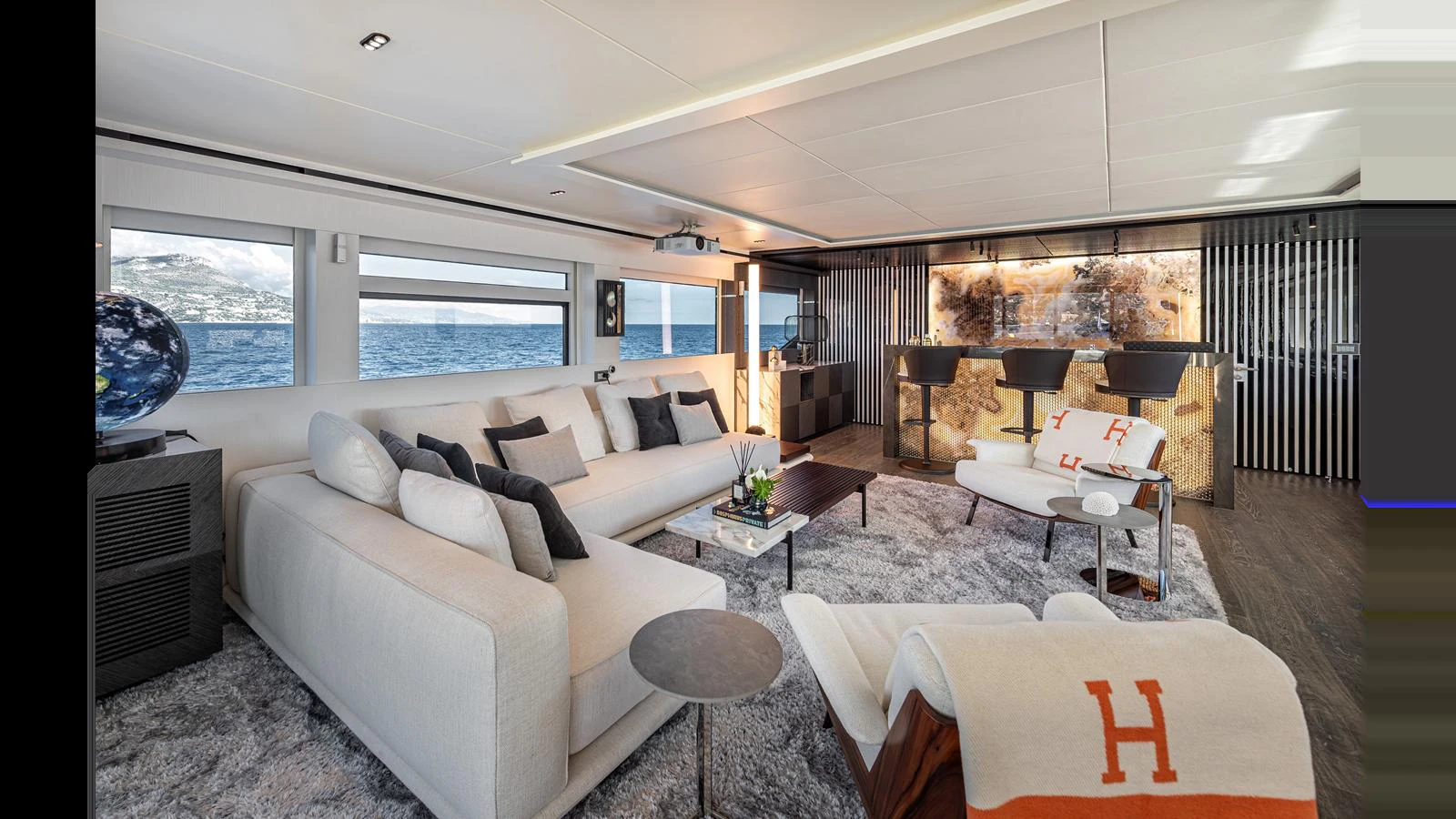 The salon features a luxurious seating area with plush sofas, a stylish bar, and large windows offering stunning ocean views. aboard NUMARINE 37XP-21 Yacht for Sale