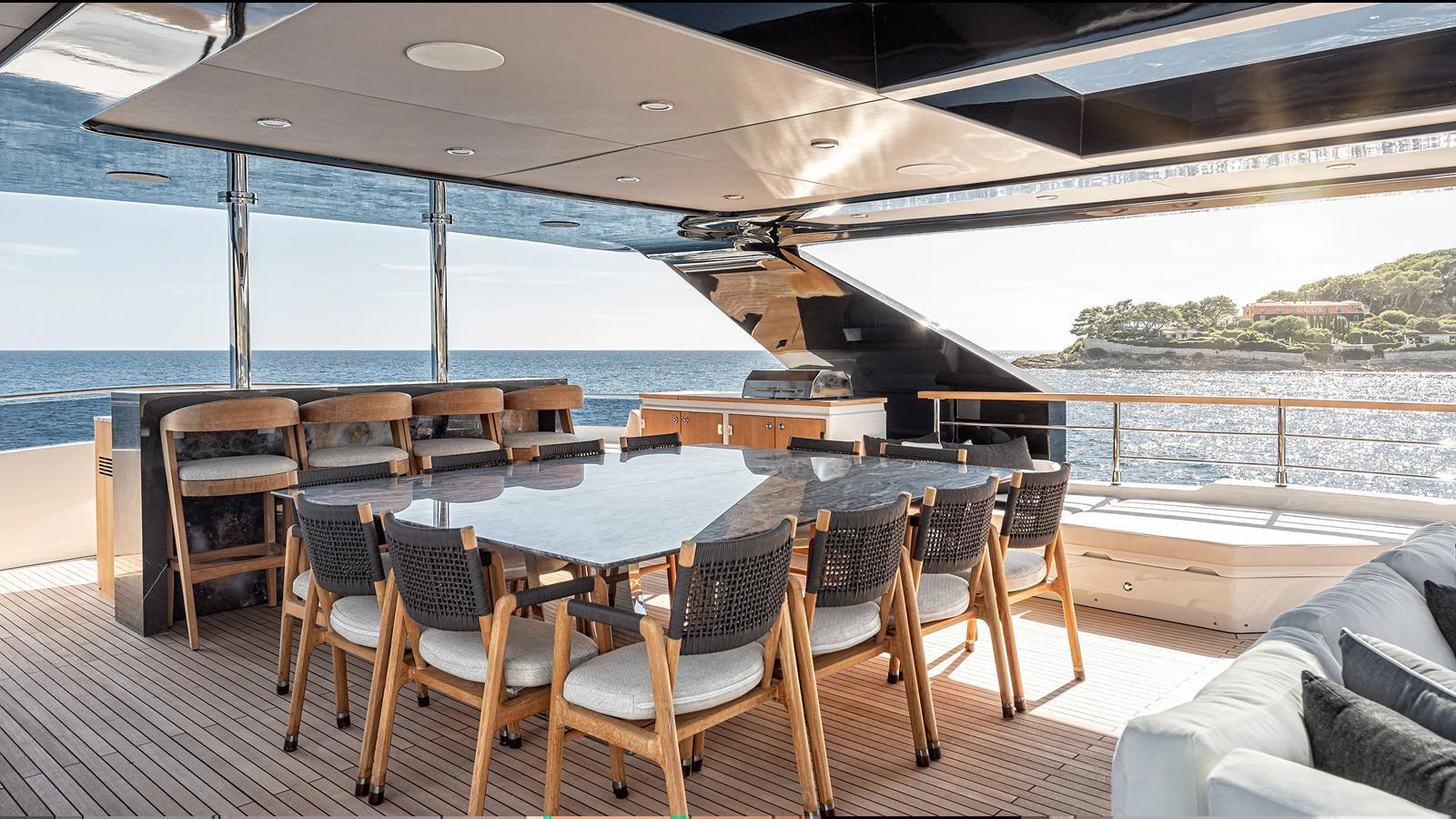 The aft deck features a spacious dining area with a large table and comfortable seating, perfect for alfresco meals with a stunning ocean view. aboard NUMARINE 37XP-21 Yacht for Sale