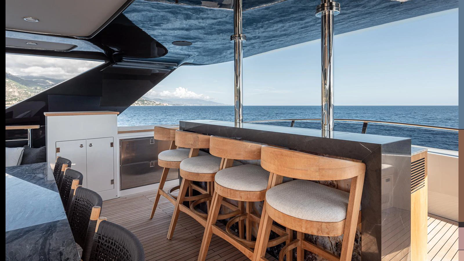 The yacht features a stylish bar area with wooden stools and a sleek countertop, perfect for enjoying drinks with a view of the sea. aboard NUMARINE 37XP-21 Yacht for Sale